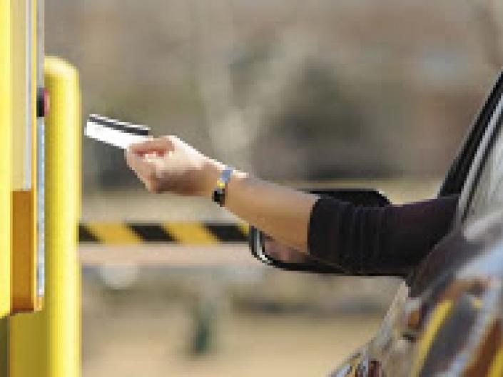 Person paying for parking with a card and a meter 