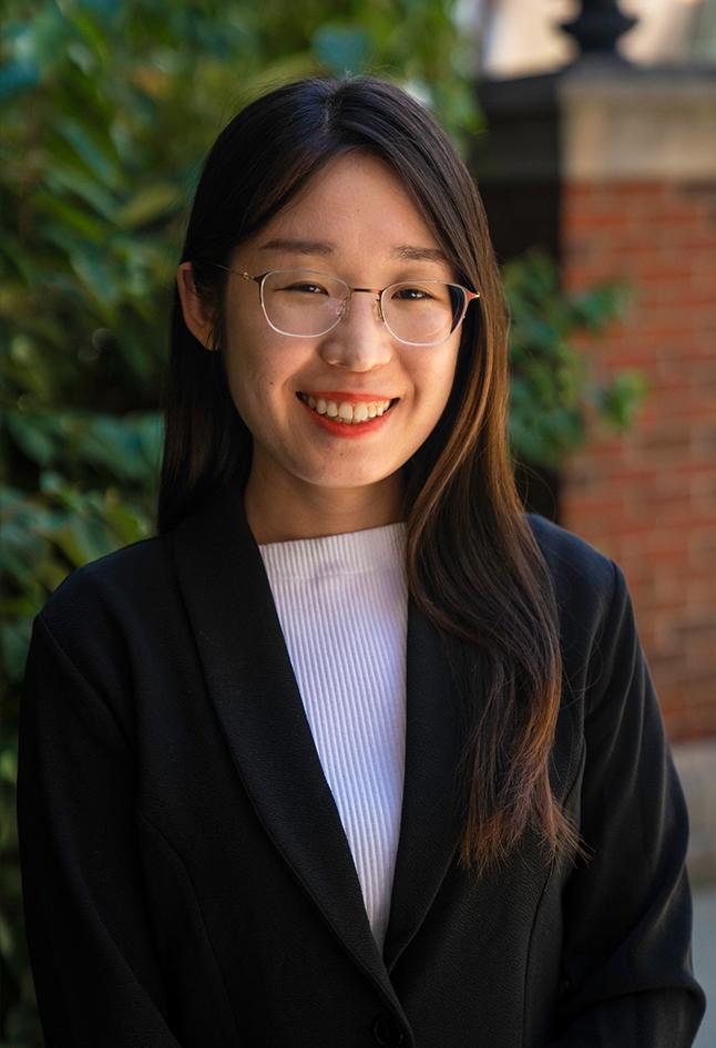 Asian woman smiling in front of trees