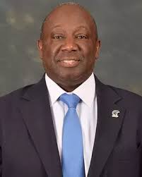 TJ Shelton wearing a dark suit and light blue tie