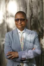 Woman standing against a tree.