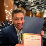 Alex  is showing his award for best talk prize.  I