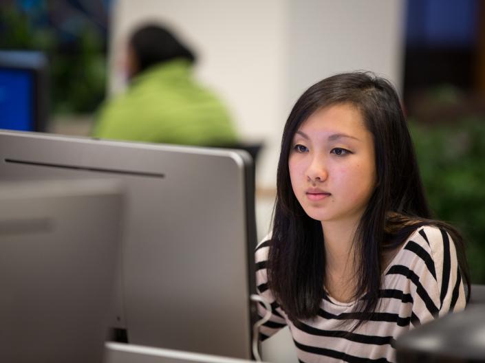 A girl sitting at a computer.