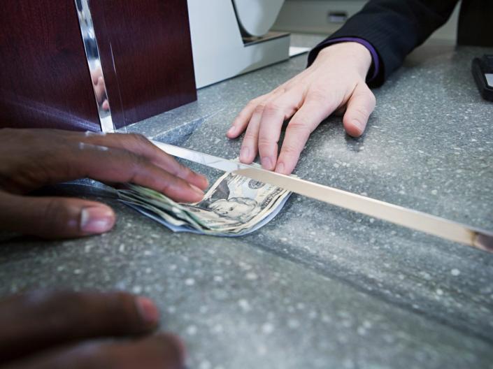 Picture of money being handed through a teller window