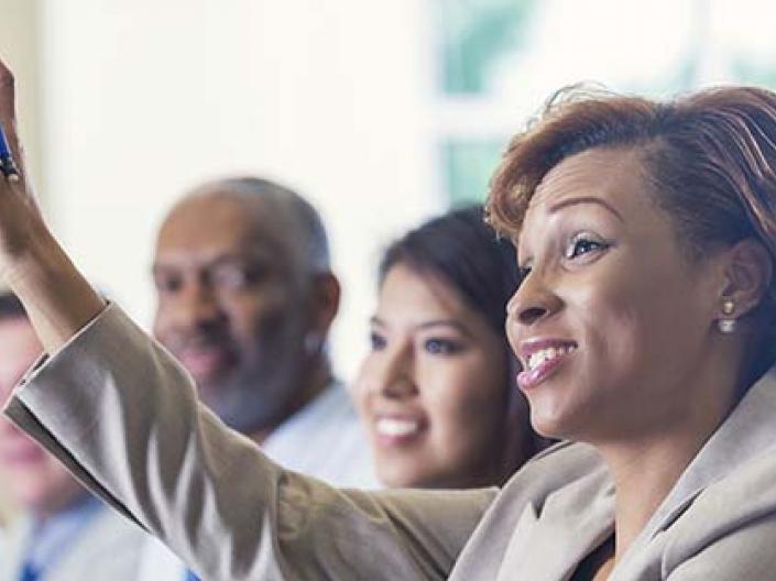 A staff member raising her hand during training