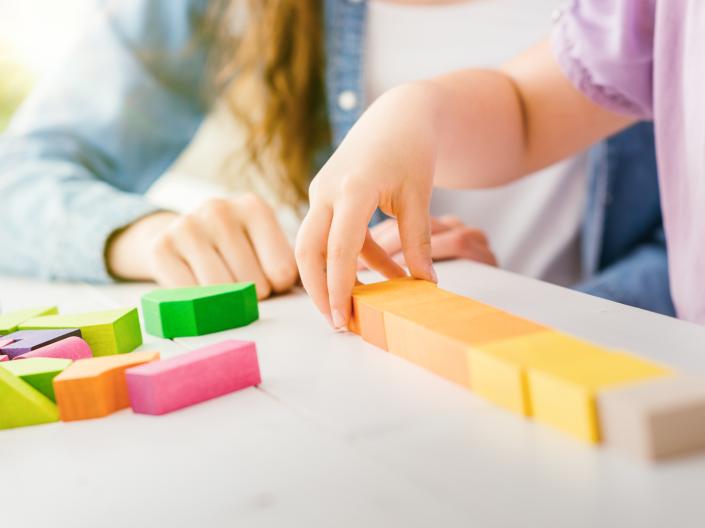 Child hand holding a block