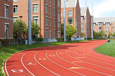 view of track on DiSanto field, with Village at 115 housing complex in background