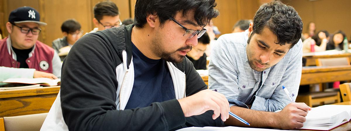 students viewing a book in class