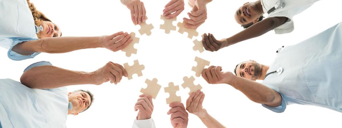 healthcare hands holding puzzle pieces in a circle