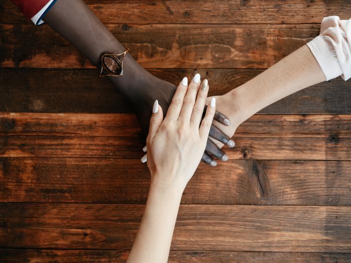 Three hands laying on top of each other