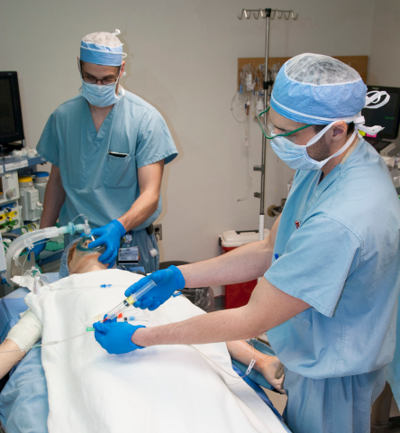 Two students in sim lab with mannequin