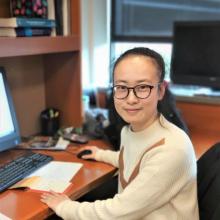 Woman with glasses and dark hair working at a computer