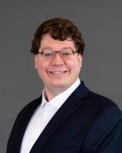 Man with glasses and dark suit