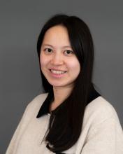 Woman with dark hair in a tan shirt