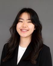 Woman with dark hair wearing a dark suit jacket