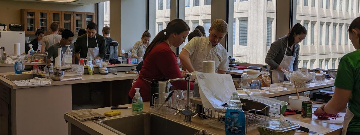 A group of students prepares recipes in a culinary lab.