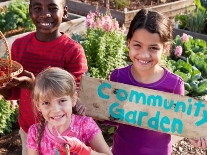 3 children standing in a community garden