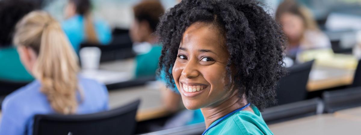 Woman wearing scrubs sitting in classroom at Case Western Reserve