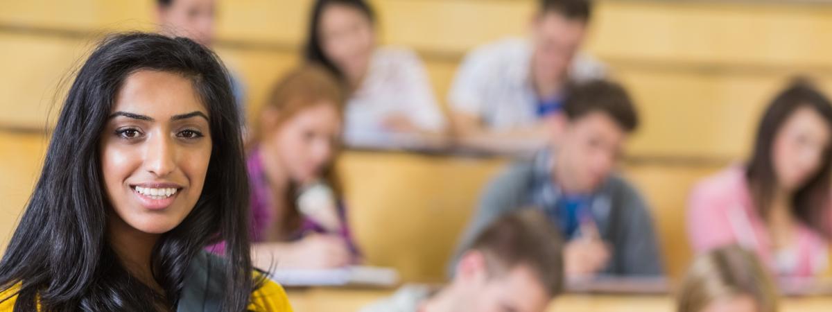 Young woman stands in front of classroom