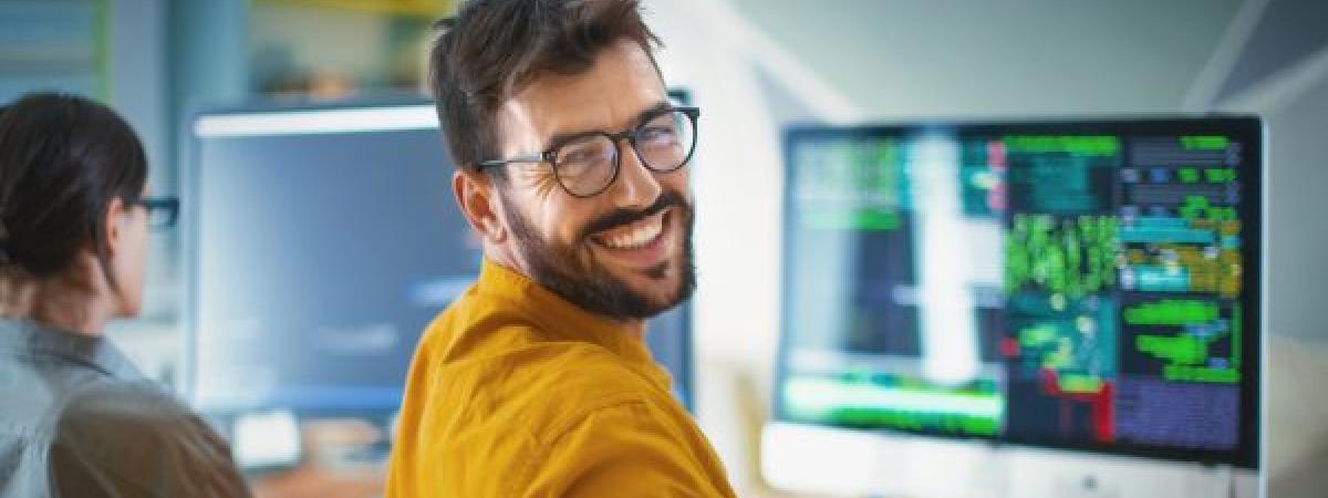 Smiling Case Western Reserve student reviews data on computer screen