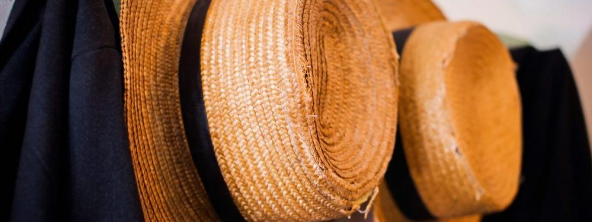 two straw hats hanging on a wall