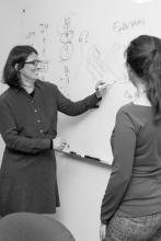 Teacher and student at Case Western Reserve writing equations on whiteboard