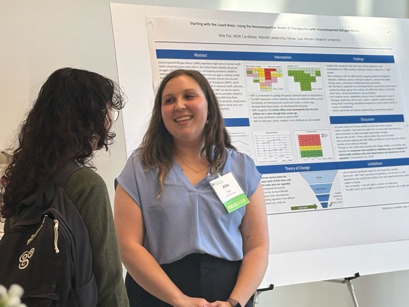 Allie Pail discusses her poster with someone