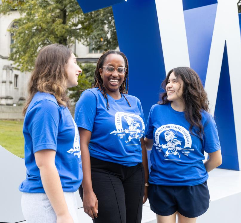 A group of three students smiling and posing in new blue CWRU t-shirts.