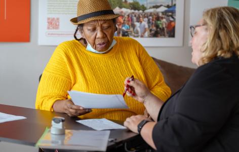 Photos of Will Clinics members and others at tables to help people write their wills.