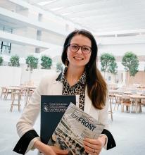 Smiling female holding Frances Payne Bolton School of Nursing Magazines