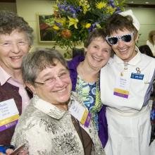 4 women celebrating during homecoming/reunion in the past