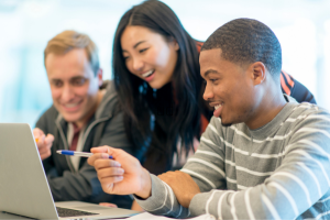 three students looking at a laptop