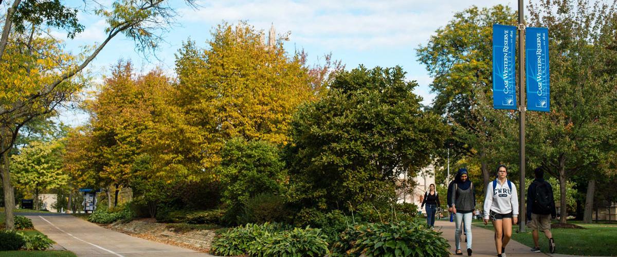 Exterior view of Case Western Reserve University campus with two students walking on a sidewalk