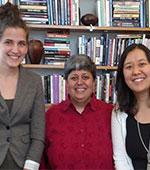 Diana with two students in front of a bookcase