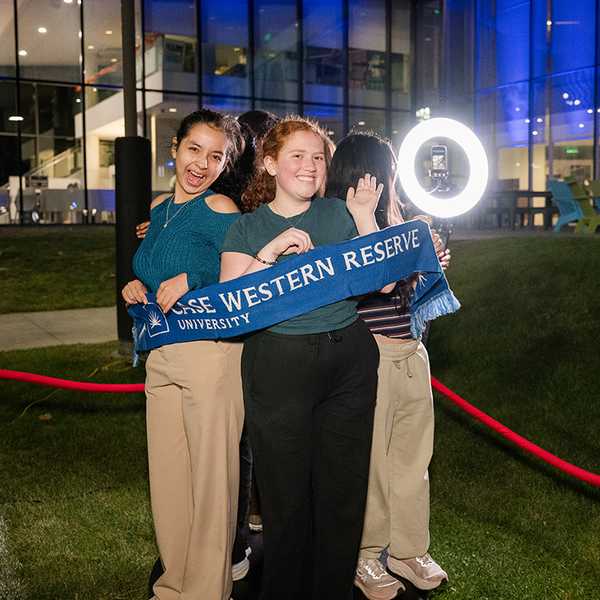 Two students holding a CWRU scarf while on a 360 camera at Blue Bash.