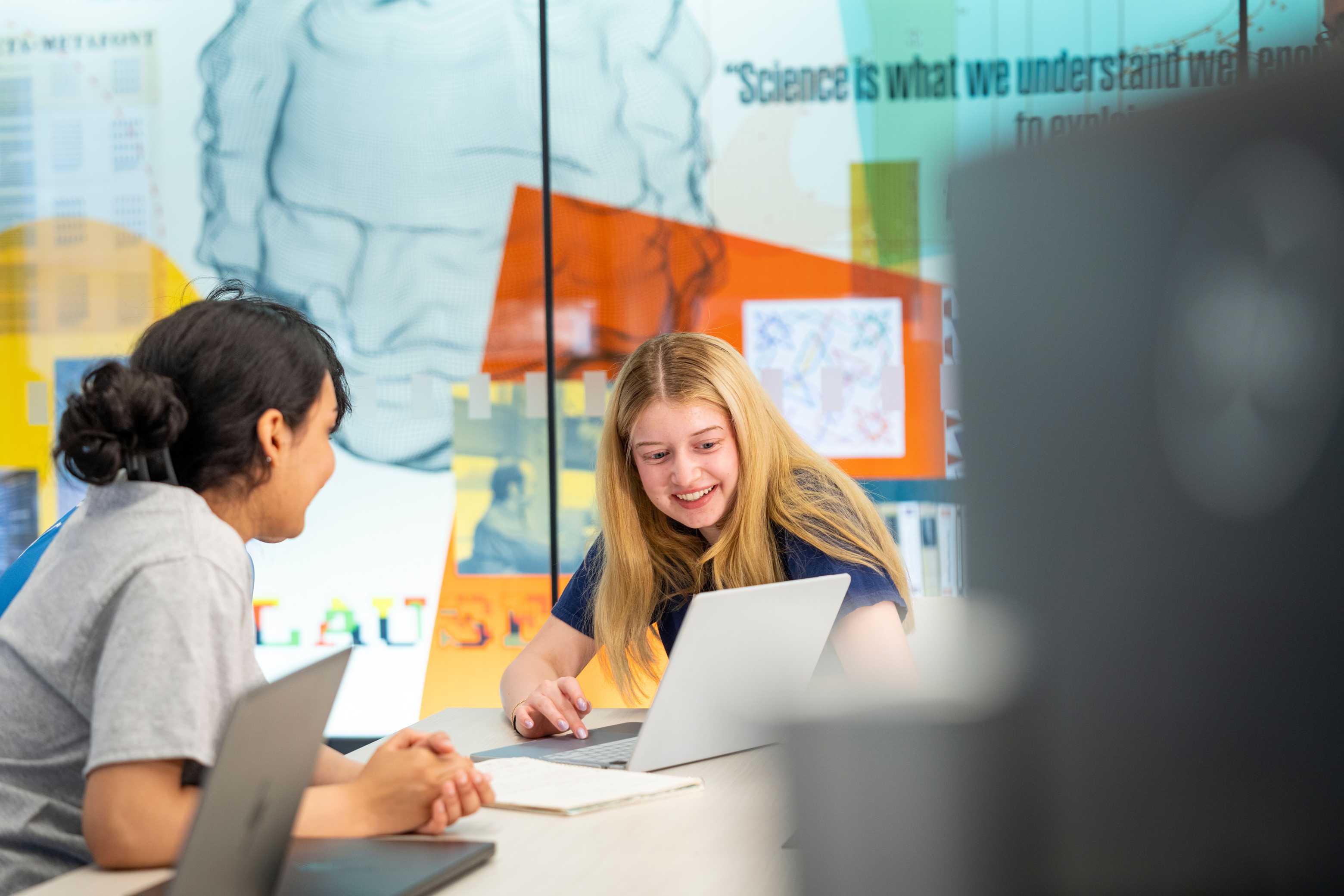 Two students work together on a laptop in Olin