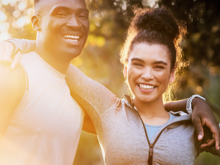 Two people standing next to each other in sunshine