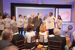 Tinkham Veale II standing on stage surrounded by CWRU students.