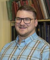 Matthew Pierleoni headshot, Matthew is wearing black glasses and a blue plaid shirt