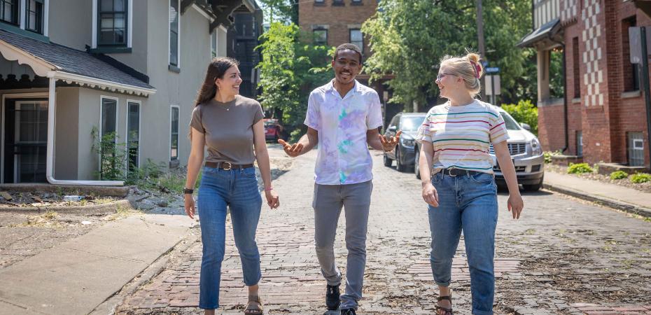 Three graduate students from the Mandel School walking in the University Circle neighborhood