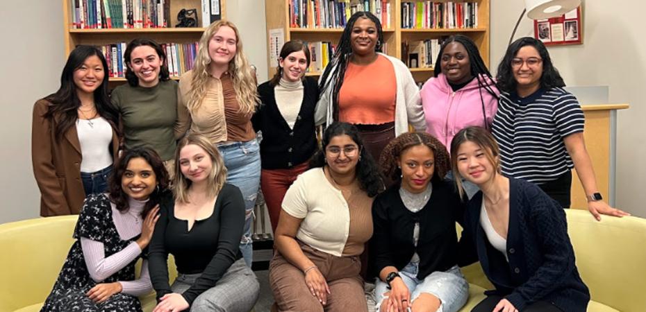 group of women standing in front of a bookcase