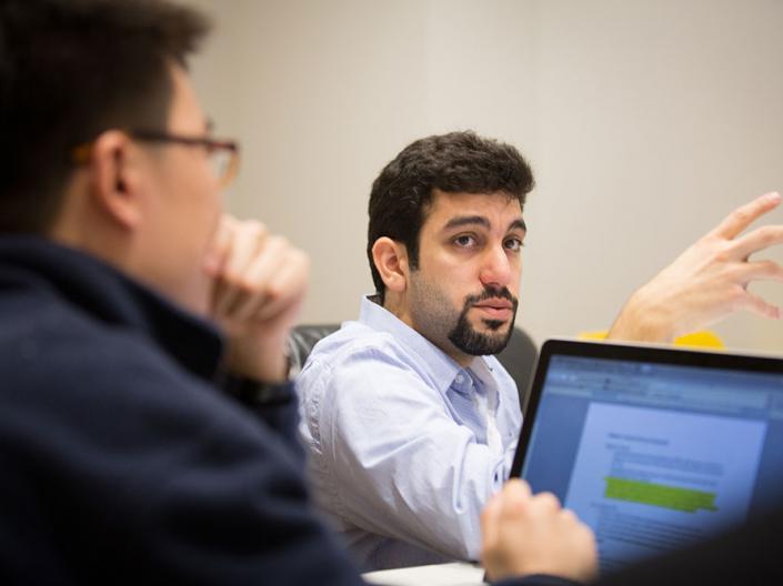 Two employees talking with a laptop in front of one