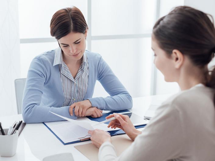 Two women viewing a document together.