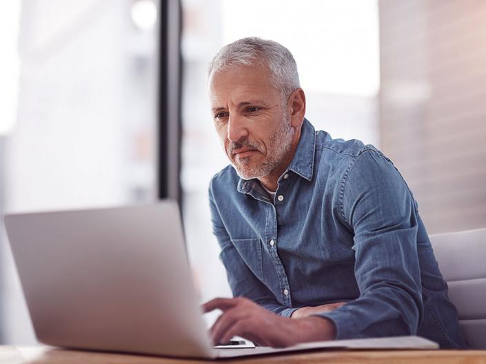 Man using a laptop to search for a job