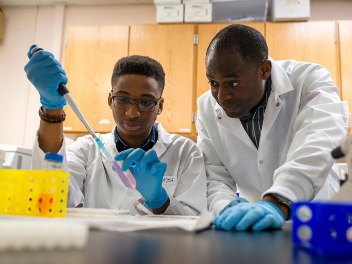 A professor working with his student in the lab