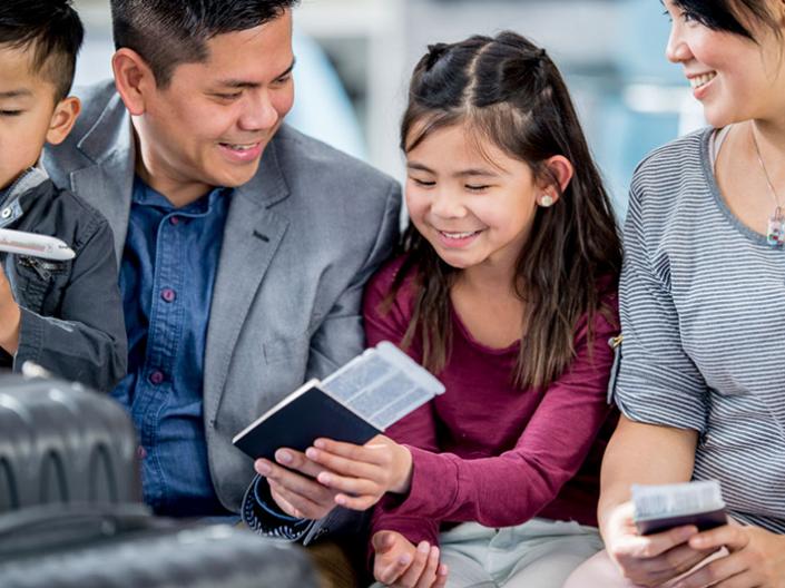 Smiling family looking at a passport.