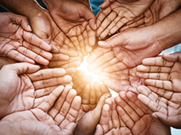 Multicultural hands clasped in unity, forming a circle of support and togetherness.