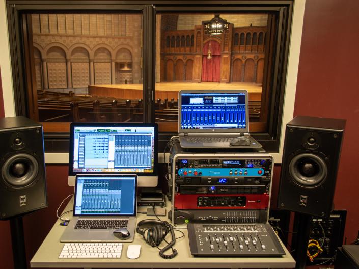 photo of three computers running ProTools and two monitors next to the desk with the computers