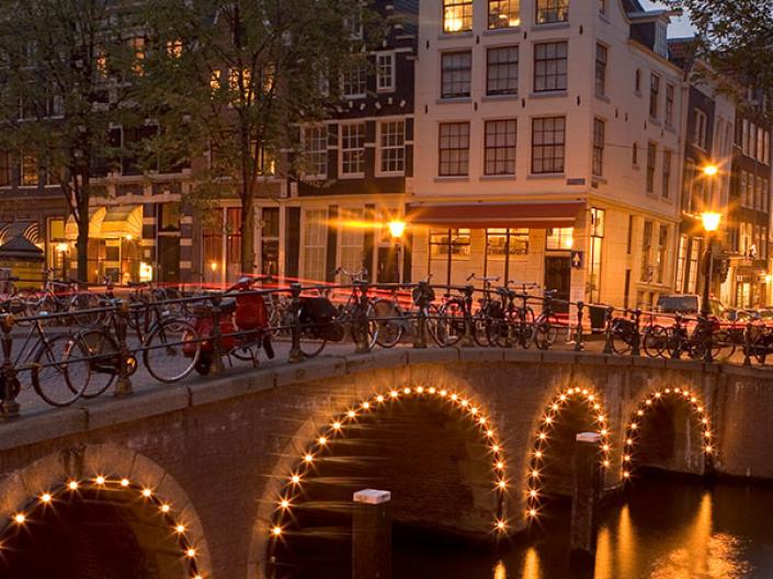 A bridge in Amsterdam with lights on it.
