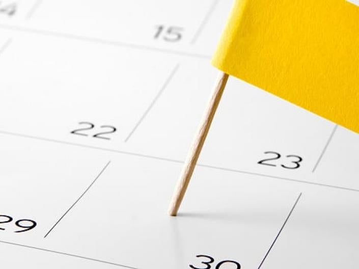 A calendar with a yellow flag.