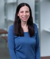 smiling woman with long dark hair and blue shirt